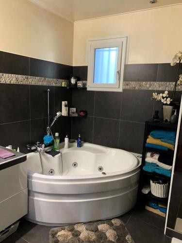 une baignoire blanche dans une salle de bain avec une fenêtre dans l'établissement Résidence Pins Parasol - Magnifique maison individuelle avec piscine privée et proche de la mer MAE-5211, à Six-Fours-les-Plages