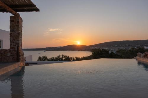 KrotiriにあるKrios Luxury Suitesの夕日を背景にしたインフィニティプール