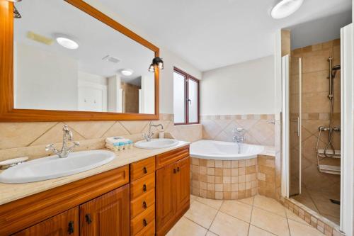 a bathroom with two sinks and a shower at Caya Bista Lama 26 in Palm-Eagle Beach