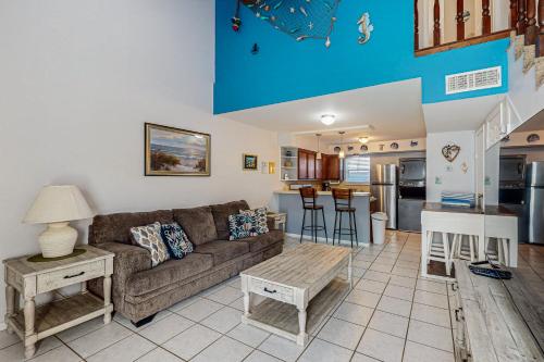 a living room with a couch and a kitchen at Leeward Cove in Padre Island