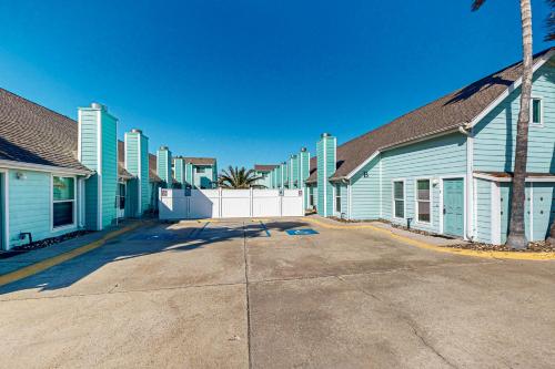 a row of blue homes with a white fence at Leeward Cove in Padre Island