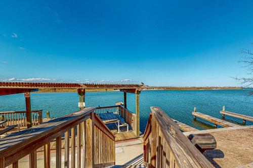 a wooden deck with benches on the water at Leeward Cove in Padre Island