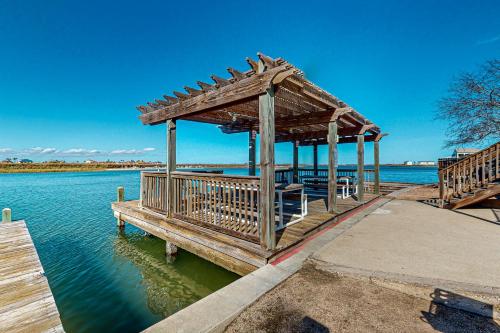 a wooden dock with a gazebo on the water at Leeward Cove in Padre Island