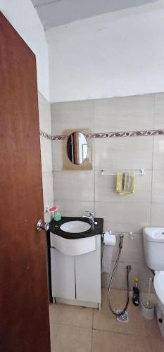 a bathroom with a sink and a toilet and a mirror at Casa Familiar en Playa Hermosa in Playa Hermosa