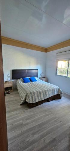 a bedroom with a large bed with blue pillows at Casa Familiar en Playa Hermosa in Playa Hermosa