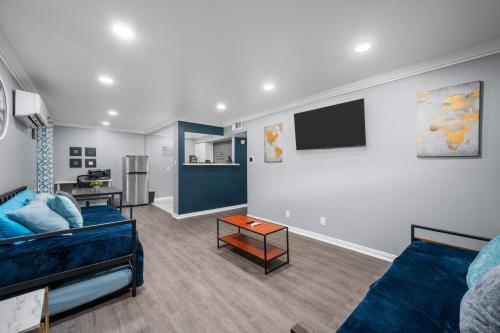 a living room with a couch and a flat screen tv at Chic 2BR Haven in Midtown - Prime Location in Houston