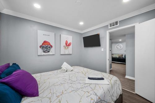 a bedroom with a bed and a flat screen tv at Chic 2BR Haven in Midtown - Prime Location in Houston