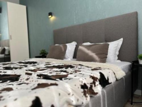 ein Bett mit einer braun-weißen Decke und Kissen in der Unterkunft ЖК New City двухкомнатные уютная апартаменты in Atyrau