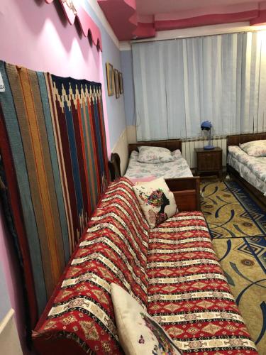 a bedroom with two beds and a blanket at Dom Polski in Gyumri