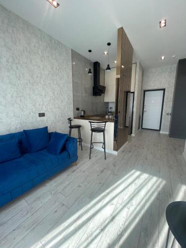un soggiorno con un divano blu e una cucina di Sapphire Apartment a Baku