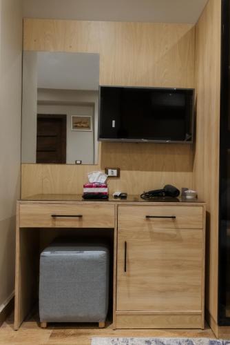 a room with a desk with a flat screen tv at Mirage pyramids view hotel in Cairo