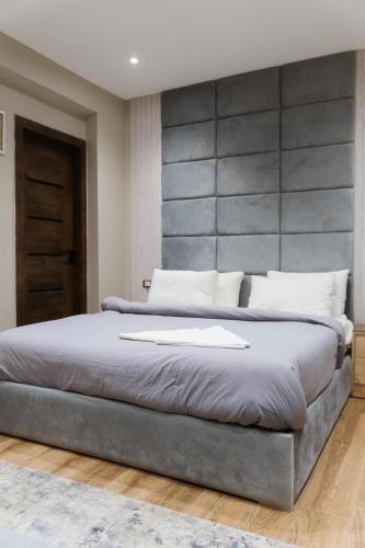 a bedroom with a large bed with a large headboard at Mirage pyramids view hotel in Cairo