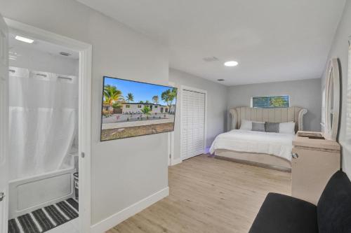 Un dormitorio con una cama y un televisor. en Vibrant Miami Escape with BBQ Grill Free WiFi & Parking, en North Miami Beach