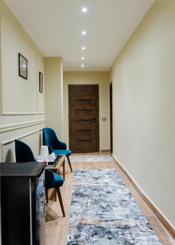 a hallway with chairs and a table and a door at Mirage pyramids view hotel in Cairo