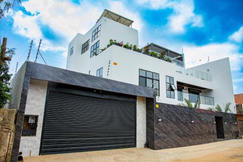 a white building with a garage at Villa Palm évasion in Ngaparou