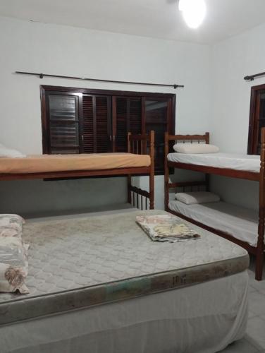 a room with three bunk beds and a window at Casa tucano in São Sebastião