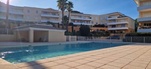 une piscine devant certains immeubles d'habitation dans l'établissement F3, 4 pers-Centre ville-Standing - Cavalaire-sur-Mer, à Cavalaire-sur-Mer