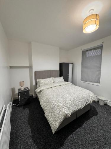 a white bedroom with a bed and a lamp at Oxborne Rooms UK - Plaistow in London