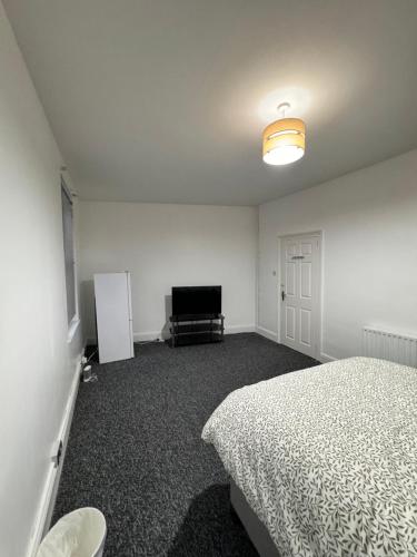 een slaapkamer met een bed en een televisie. bij Oxborne Rooms UK - Plaistow in Londen