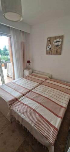 une chambre avec deux lits et un tableau au mur dans l'établissement F3, 4 pers-Centre ville-Standing - Cavalaire-sur-Mer, à Cavalaire-sur-Mer