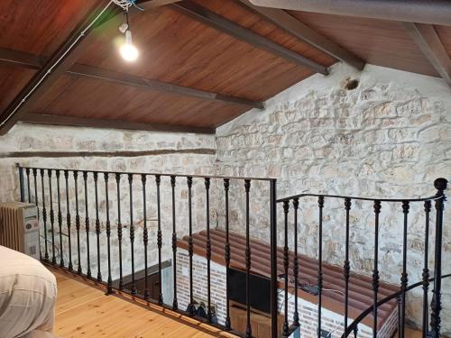 a room with a stone wall with a bench at El altillo de Valbonilla in Burgos