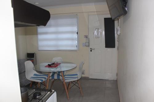 a small kitchen with a small table and chairs at dpto #5 in Neuquén