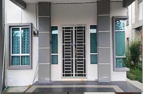 a white house with a door and windows at Juliana Homestay in Jitra