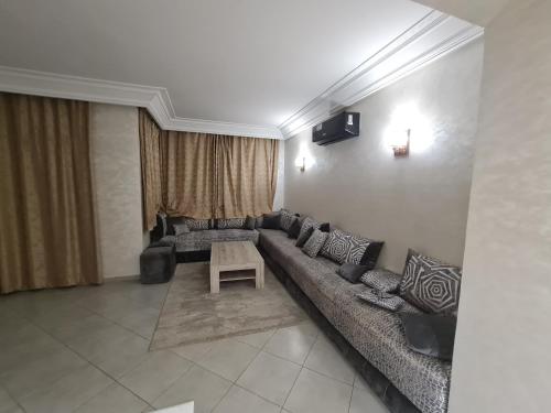 sala de estar con sofá largo y mesa en résidence ATLASS, en Marrakech