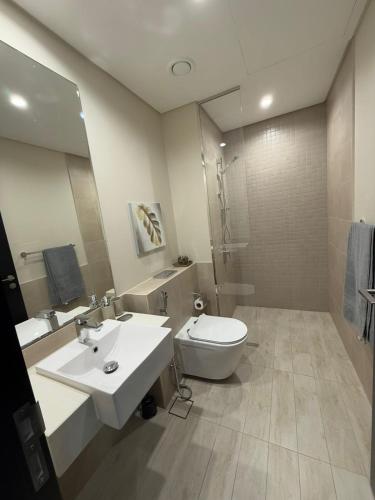 a bathroom with a sink and a toilet and a mirror at Luxury 2BR Close to Sheikh Zayed Rd, Prime Location, Burj View Opposite Metro in Dubai