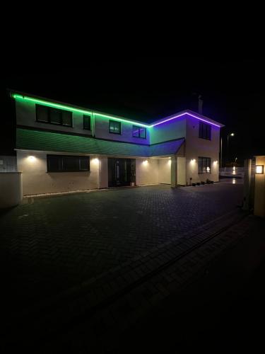 a building with purple and green lights on it at night at Falcon house 7 bedrooms in Hawley
