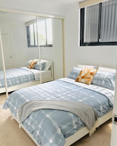 a bedroom with two beds and a mirror at 2BR Apartment in Rockdale Near Airport & Train Station in Sydney