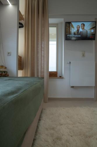 a bedroom with a bed and a tv on the wall at Garden's House Pozar in Aridaia in Aridaia