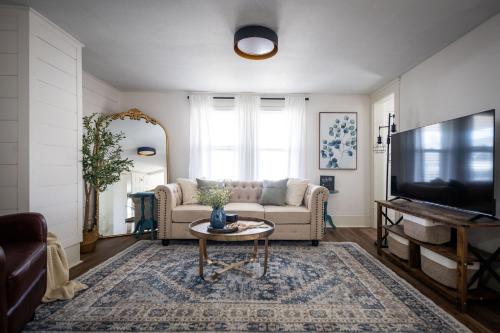 a living room with a couch and a table and a tv at Walkable to Everywhere in Little Italy- Near CWRU and Cleveland Clinic Main Campus in Cleveland