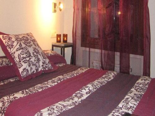 a bedroom with a bed with a red and white comforter at Apartamentos Casbas in Sorripas