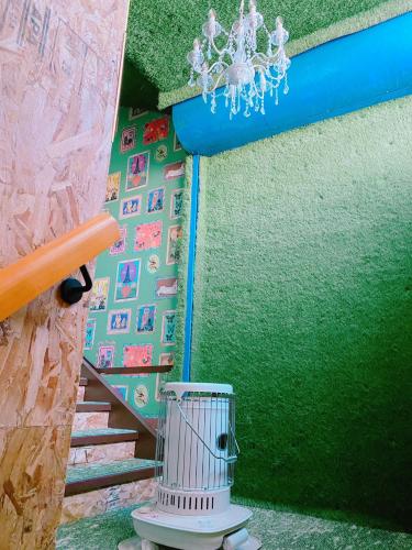 a staircase with a bird cage next to a green wall at 別海町greenstar in Nishi-shumbetsu