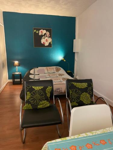 Cette chambre comprend un lit et deux chaises. dans l'établissement Studio n•4 en plein cœur de la ville thermal, à Bagnères-de-Bigorre