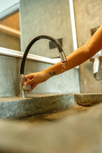 a person is washing their hands in a sink at The Quale Villa in Galle