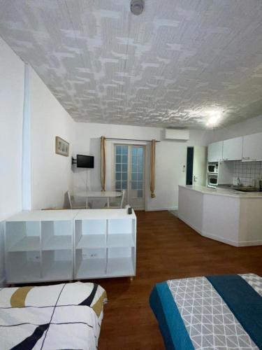 une chambre avec deux lits et une cuisine dans l'établissement Studio N•2 avec patio en plein cœur de la ville, à Bagnères-de-Bigorre