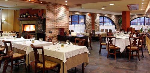um restaurante com mesas e cadeiras com toalha de mesa branca em Apartamentos Casbas em Sorripas