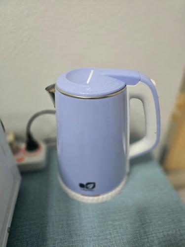 a white coffee cup sitting on a counter at 104 Peaceful and Cosy apartment with cool fan near BTS with free WiFi in Bangkok