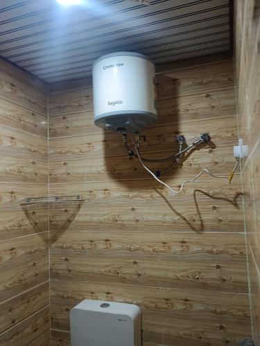 a bathroom with a toilet and a light on the wall at Radhika Hotel in Jaipur