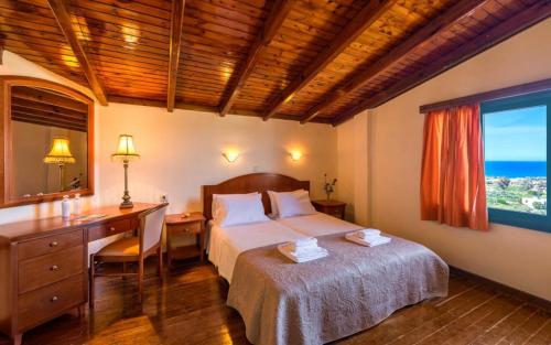 una camera con letto, scrivania e finestra di Antilia Apartments a Tavronitis