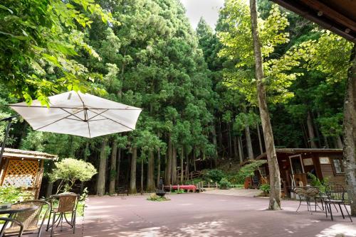 a table with an umbrella in the middle of a forest at クースクース in Fujikawaguchiko
