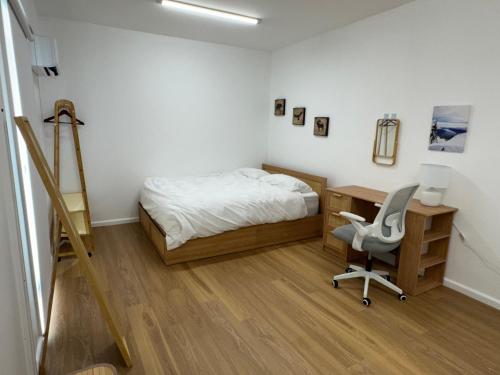 a bedroom with a bed and a desk and a chair at Quiet and Cozy corner in Braybrook