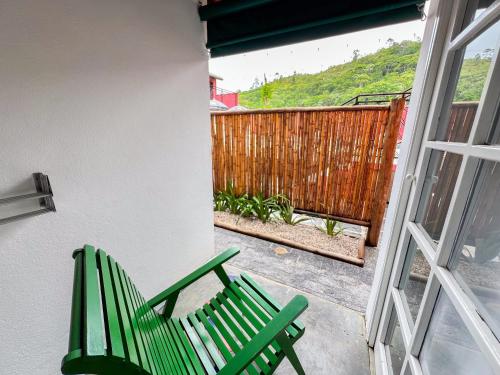 a pair of green chairs sitting on a patio at Pousada Promessa Amanay antigamente Ubatuba Guest House in Ubatuba