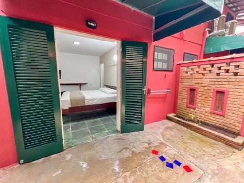 a room with red walls and a bedroom with a bed at Pousada Promessa Amanay antigamente Ubatuba Guest House in Ubatuba