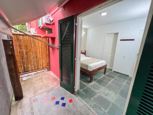 a room with a room with a bed and a door at Pousada Promessa Amanay antigamente Ubatuba Guest House in Ubatuba