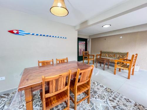 a dining room with a wooden table and chairs at Pousada Promessa Amanay antigamente Ubatuba Guest House in Ubatuba