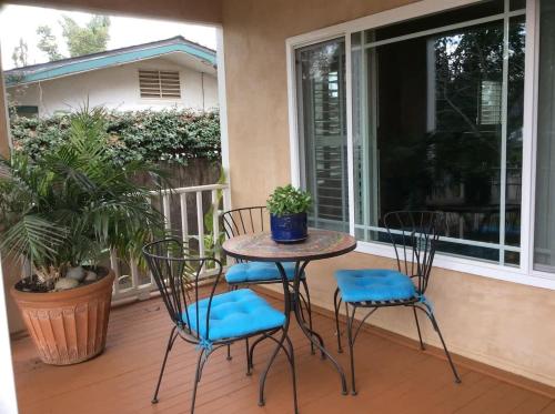 a patio with two chairs and a table on a porch at Seq Parks-House with Hot Tub Fire Pit Koi Pond Outdoor Kitchen in Visalia