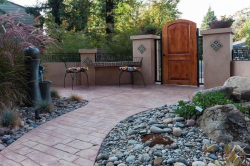 a patio with a bench and a wooden door at Seq Parks-House with Hot Tub Fire Pit Koi Pond Outdoor Kitchen in Visalia
